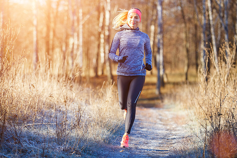 Frau joggt durch den Wald Frau joggt durch den Wald