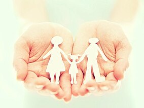 Illustration: Familie in einer Hand