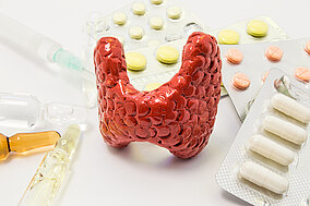 Modell einer Schilddrüse und Medikamente