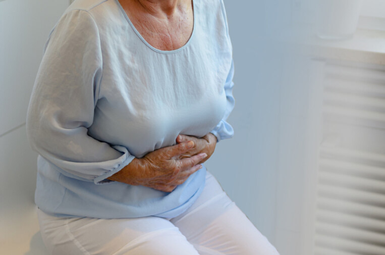 Ältere Frau hält sich vor Schmerz den Bauch Ältere Frau hält sich vor Schmerz den Bauch