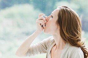 Frau mit Asthmainhalator