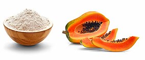 Aufgeschnittene Papaya und eine Holzschale gefüllt mit Mehl