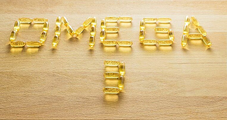 Omega-3 capsules against a wooden background.  Omega-3 capsules against a wooden background.