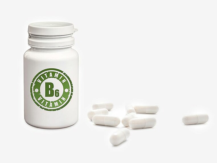 Dose mit der Aufschrift Vitamin B6 und danebenliegende Kapseln Dose mit der Aufschrift Vitamin B6 und danebenliegende Kapseln