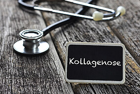 Stethoskop und ein Schild mit der Aufschrift "Kollagenose" liegt auf einem Tisch 