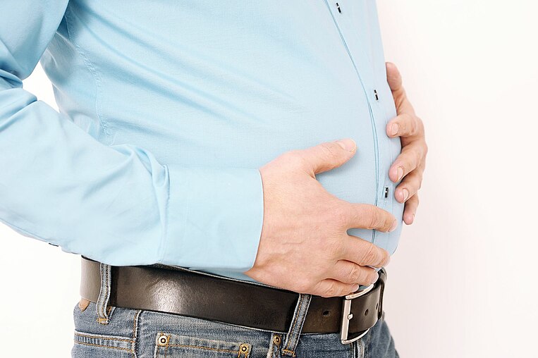 Mann hält sich den Bauch Mann hält sich den Bauch