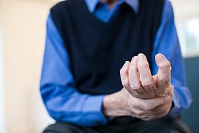 An older man holding his wrist