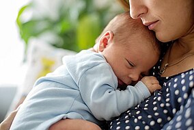 Neugeborenes Baby liegt auf der Brust der Mutter