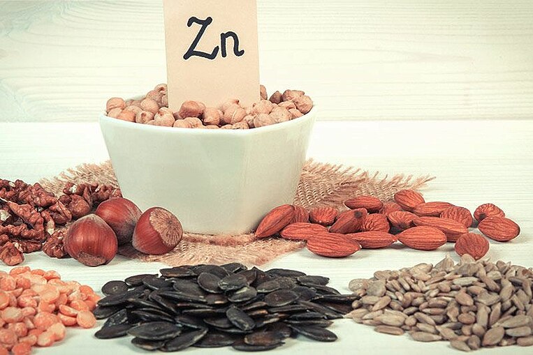 Verschiedene Nüsse und Körner um eine Schüssel mit einem Zettel mit der Aufschrift ZN Verschiedene Nüsse und Körner um eine Schüssel mit einem Zettel mit der Aufschrift ZN