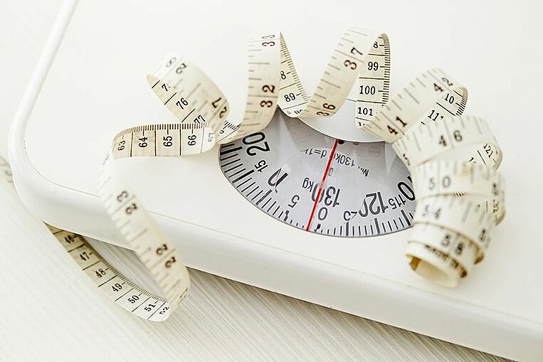 Bilancia con sopra un metro a nastro Waage auf der ein Messband liegt