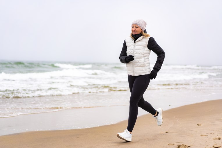 Frau am Meer am joggen