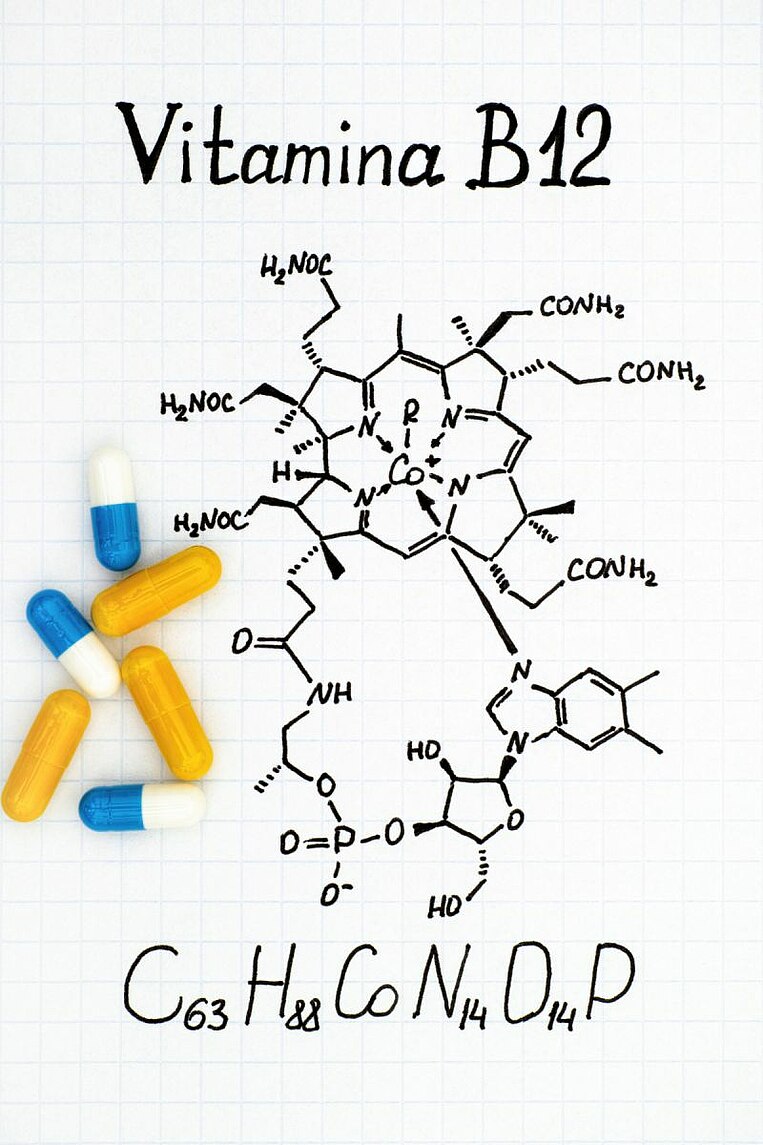 Formula chimica della vitamina B12 con accanto delle capsule Formula chimica della vitamina B12 con accanto delle capsule