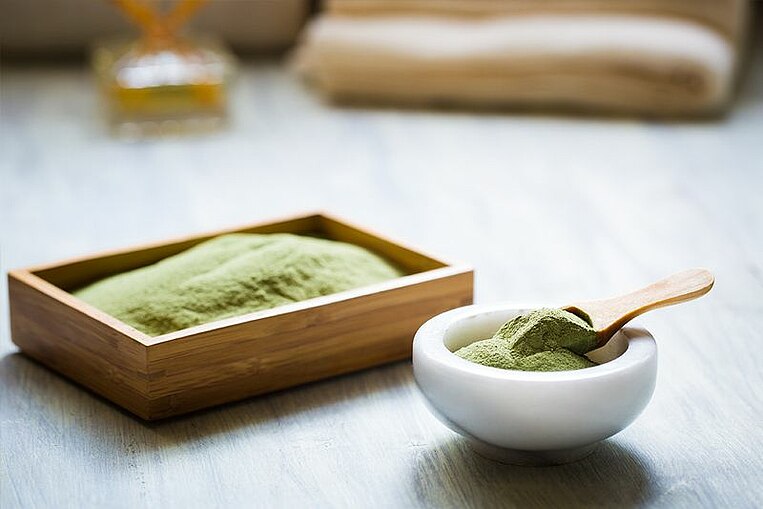 Spirulinapulver in einer Keramikschüssel Spirulinapulver in einer Keramikschüssel