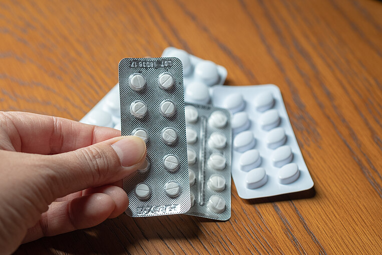 Person hält eine Tablettenpackung in der Hand Person hält eine Tablettenpackung in der Hand