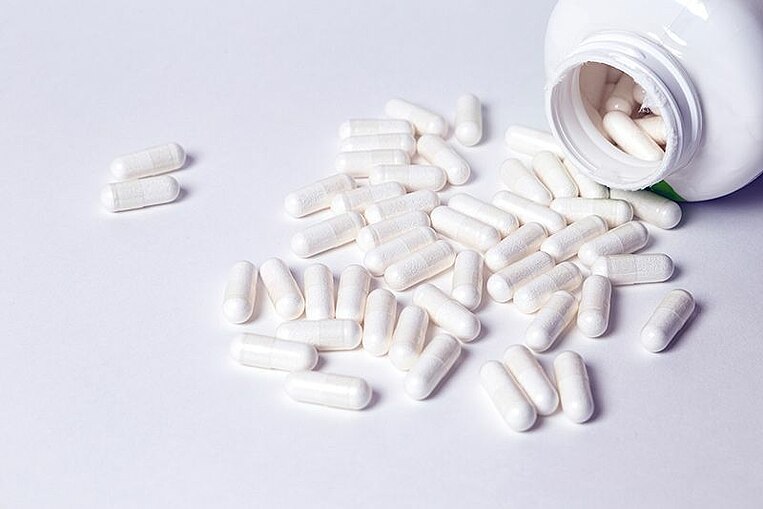 Kapseln, die aus einer Dose geschüttet sind Kapseln, die aus einer Dose geschüttet sind