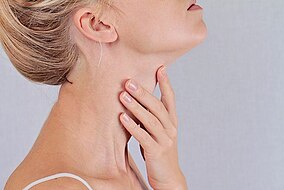 Una donna si tocca la tiroide
