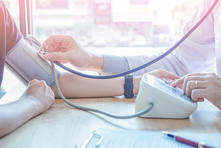 Arzt misst bei einem Patienten Blutdruck Arzt misst bei einem Patienten Blutdruck