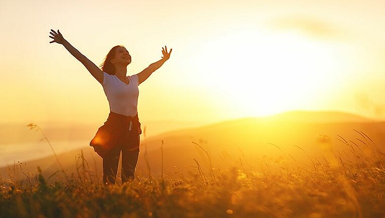 Frau steht in der Natur im Sonnenschein Frau steht in der Natur im Sonnenschein