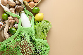 Einkaufsnetz mit verschiedenem Gemüse, Obst, Eiern und Milch