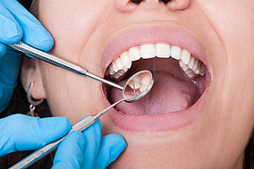 Zahnarzt untersucht die Zähne seiner Patientin