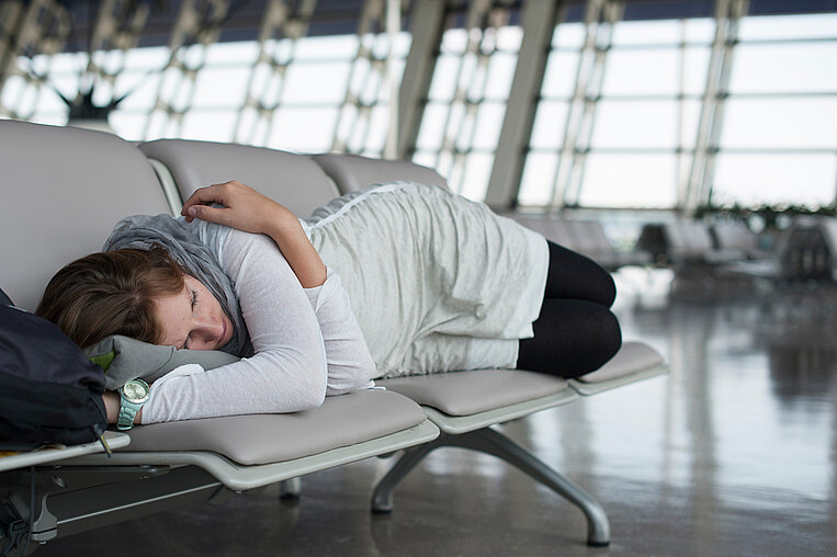 Frau schläft in einem Flughafen Frau schläft in einem Flughafen