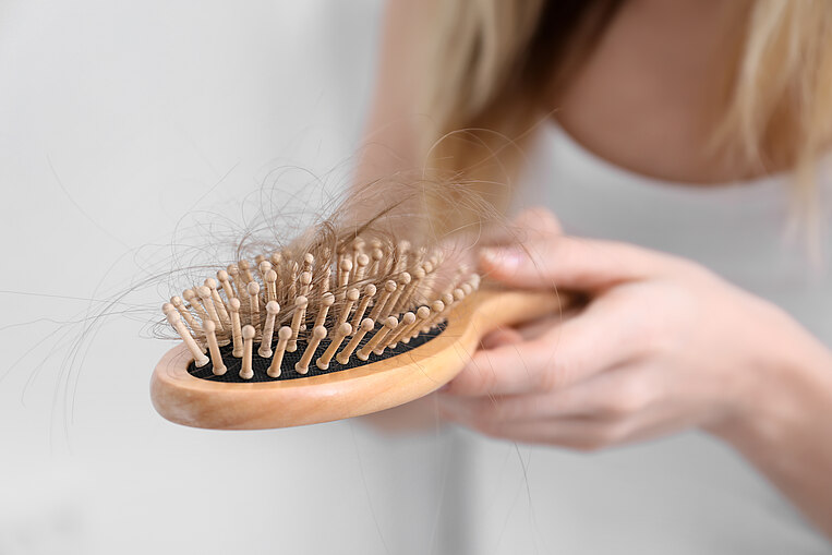 Frau hält Haarbürste in der Hand Frau hält Haarbürste in der Hand
