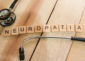 Stetoscopio e la parola "neuropathie" scritta con cubi di legno con lettere