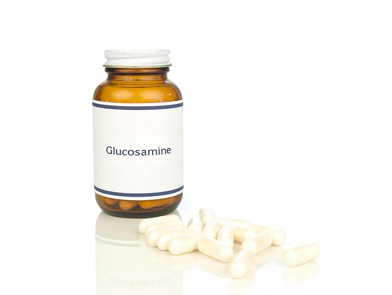 Dose mit der Aufschrift Glucosamin und davorliegende Kapseln Dose mit der Aufschrift Glucosamin und davorliegende Kapseln