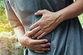 A man holding his stomach due to pain