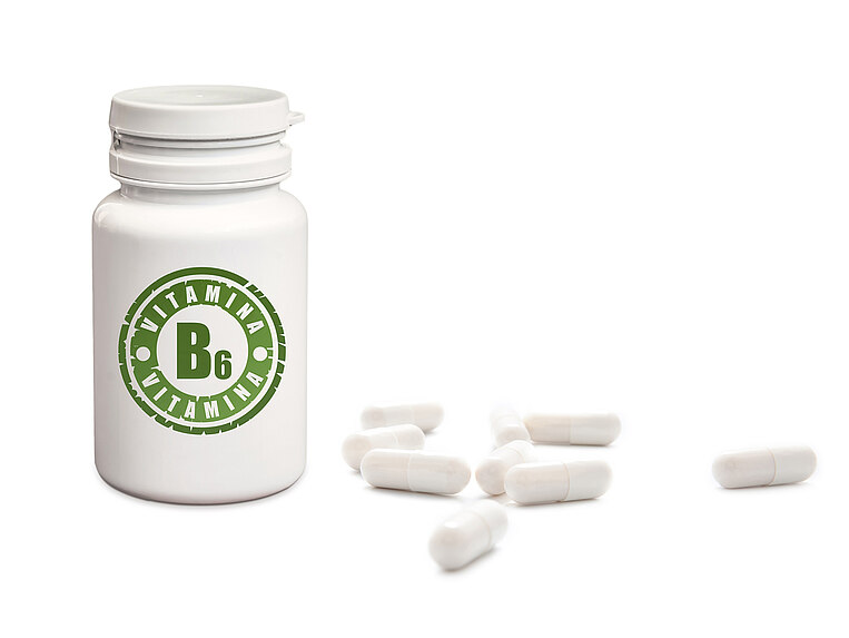 Contenitore con la scritta Vitamina B6 e con accanto delle capsule Contenitore con la scritta Vitamina B6 e con accanto delle capsule