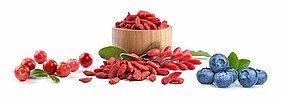 Bacche di goji, mirtilli e cranberry su sfondo bianco