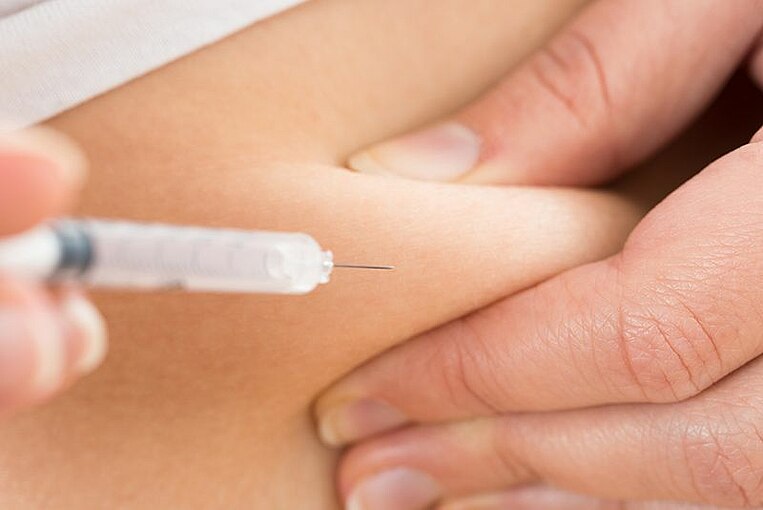 Spritze wird in eine Hautfalte eingeführt Spritze wird in eine Hautfalte eingeführt