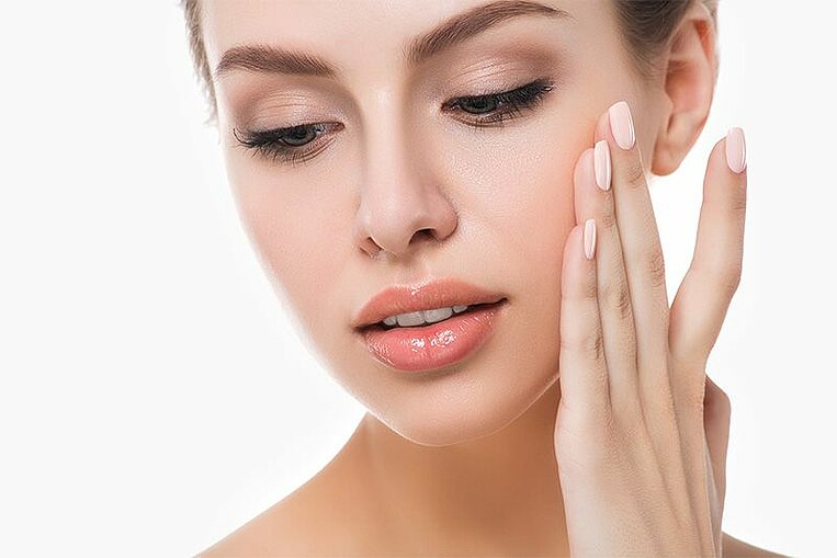 Una donna si accarezza il visto Frau streichelt ihr Gesicht