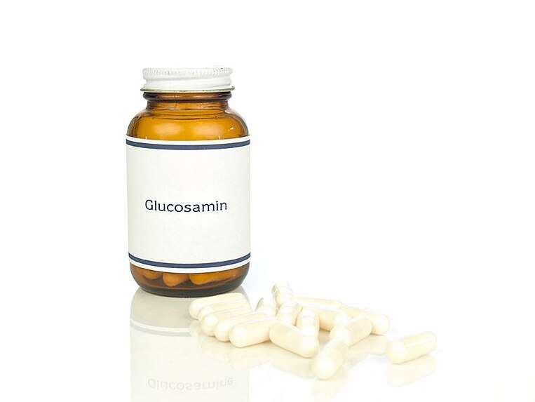 Kapseln und ein Fläschchen mit der Aufschrift Glucosamin Kapseln und ein Fläschchen mit der Aufschrift Glucosamin