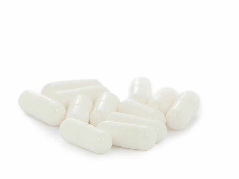 Weiße Kapseln auf weißem Hintergrund Weiße Kapseln auf weißem Hintergrund