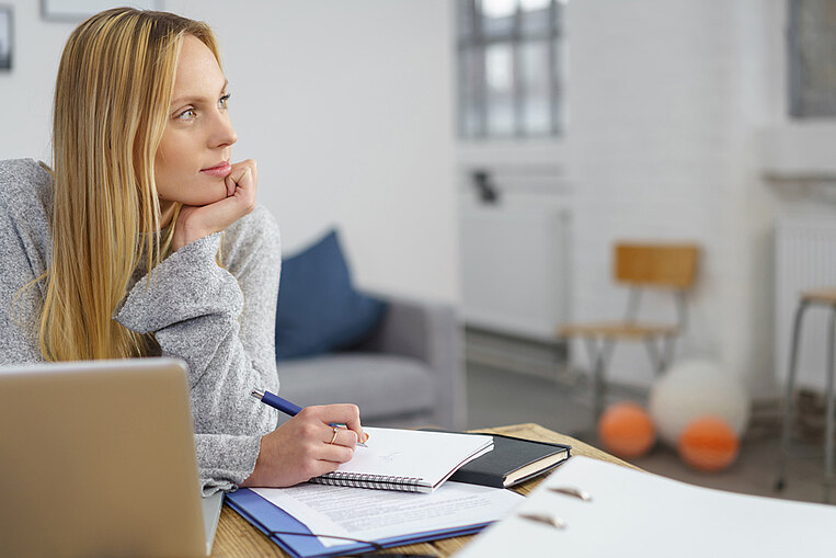 Frau schaut konzentriert beim Arbeiten Frau schaut konzentriert beim Arbeiten