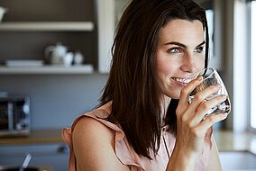 Frau mit einem Glas Wasser in der Hand