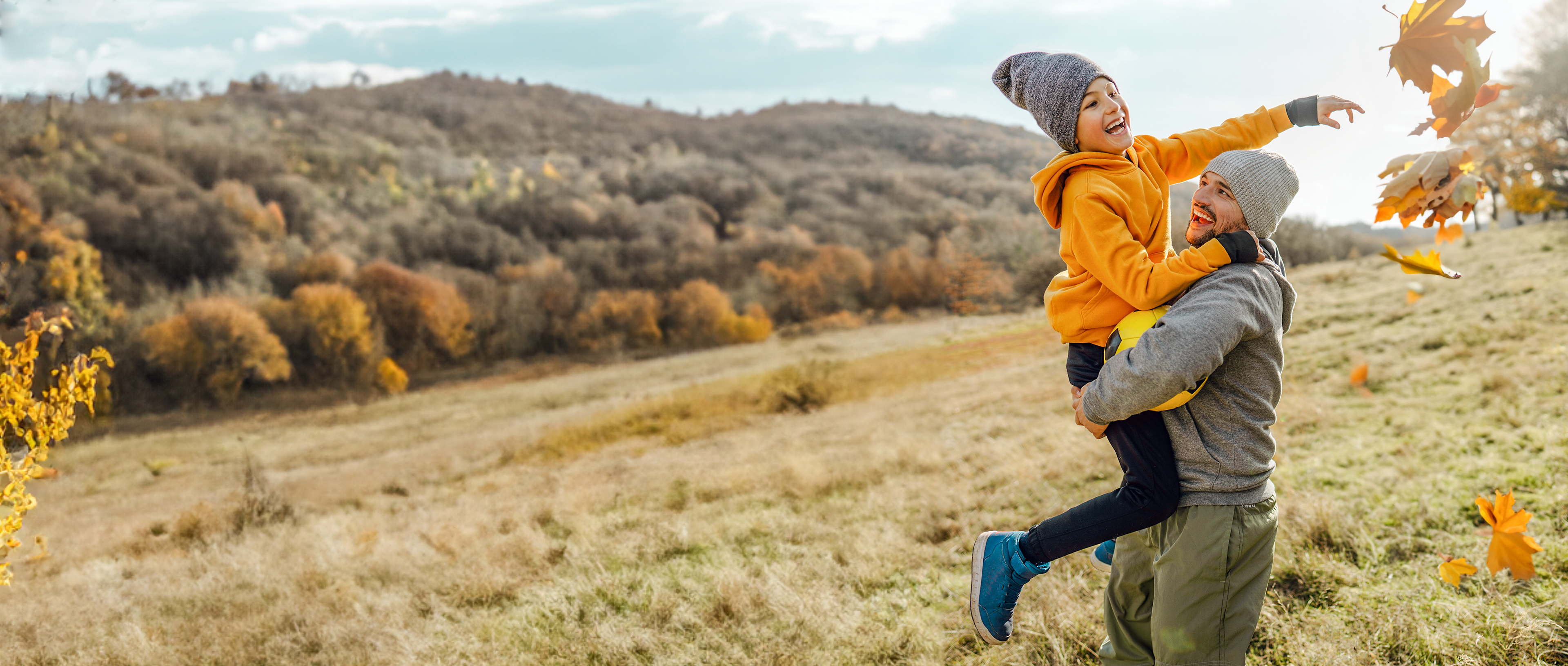 Father and son romping on a meadow