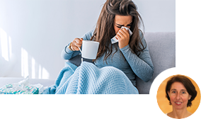 Frau sitzt mit Taschentuch und Teetasse auf einem Sofa Frau sitzt mit Taschentuch und Teetasse auf einem Sofa