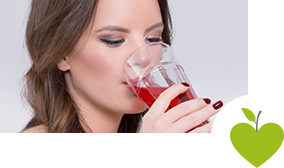 Junge Frau trinkt ein Glas Cranberrysaft Junge Frau trinkt ein Glas Cranberrysaft
