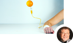 Eine Person bekommt eine Infusion aus einer Orange Eine Person bekommt eine Infusion aus einer Orange